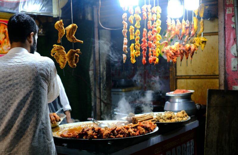 Beyond the Wazwan A man standing in front of a buffet filled with food